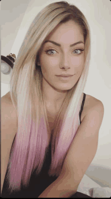 a woman with long blonde hair and pink highlights