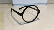 a pair of black round glasses with a clear lens