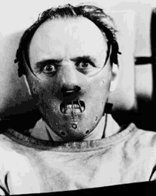 a black and white photo of a man with a mask on his face and mouth .