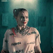 a woman in a harley quinn shirt is standing in the rain .