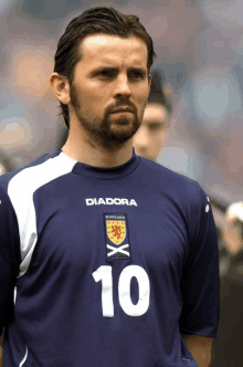 a man with a beard wears a diadora shirt with the number 10 on it