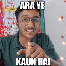 a young man wearing glasses is pointing at the camera with a funny meme .