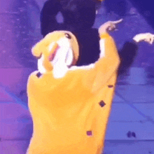 a person in a mickey mouse costume is dancing on stage .