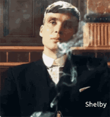 a man in a suit and tie is smoking a cigarette while looking at the camera .