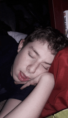 a young man sleeping with a lego book in the background