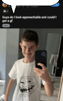 a boy taking a selfie with a troll face shirt on