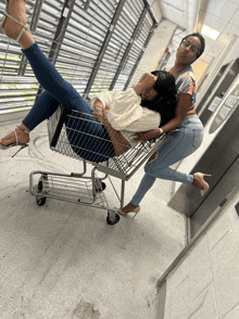 a woman is laying in a shopping cart next to a sign that says elevator