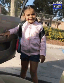 a little girl with a backpack is standing in front of a car door with collab clips on the bottom