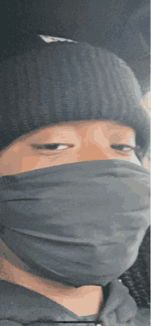 a person wearing a beanie and a black mask