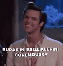 a man in a white suit is smiling and says burak 'in issizliklerini goren dusky .