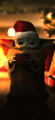 a baby yoda wearing a santa hat is holding a christmas present .