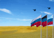 three russian flags are flying in a field with planes flying overhead