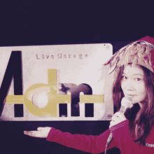 a woman stands in front of a live garage sign