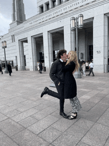 a couple kissing in front of the church of jesus christ of latter day saints