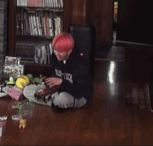 a man with red hair is laying on the floor in front of a bookshelf with foreign writing on it