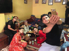 a man taking a selfie with a group of people in a room