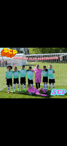 a group of young boys are posing for a picture in front of a soccer goal sponsored by scp sporting club portmouth