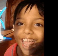 a close up of a young boy 's face with his tongue out .