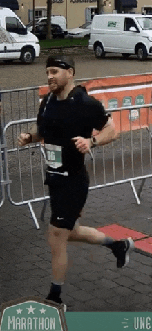 a man is running a marathon in a black shirt and shorts .