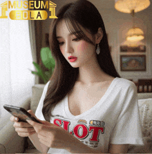 a woman wearing a white t-shirt that says slot is looking at her phone