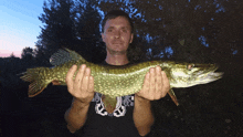 a man is holding a large fish in his hands