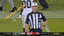 a referee stands on a football field with the words " i 'm a bad referee " on the screen behind him