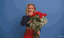 a woman is holding a bouquet of red roses in front of a blue background that says dark hearts on it