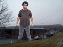 a giant man stands in front of a building that says ' eagles ' on it