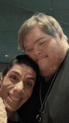 a man with down syndrome and a woman smile for a picture