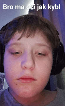 a boy wearing headphones with the words bro ma oci jak kybl on the bottom of his face