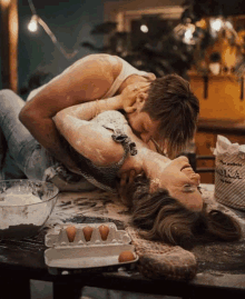 a box of flour sits on a counter next to a man and woman