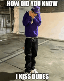 a man in a purple hoodie and a ny hat is standing in a parking lot