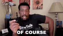 a man wearing a black shirt that says startalk of course on it