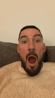 a man with a beard is making a surprised face with his mouth wide open