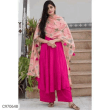 a woman is wearing a pink dress with a dupatta and sandals .