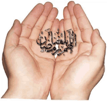 a person 's hands are holding a arabic calligraphy in their palms .