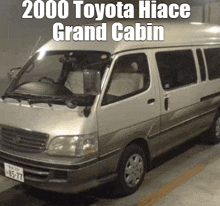 a silver toyota hiace grand cabin is parked in a parking lot