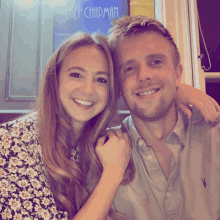 a man and a woman posing for a picture in front of a sign that says amber chapman