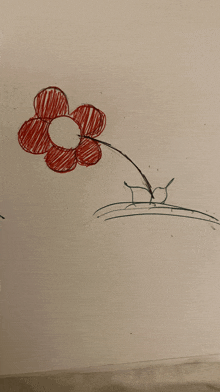 a child 's drawing of a red flower on a white surface