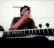 a man wearing glasses is playing a sitar with his finger