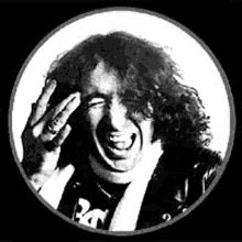 a man with curly hair is laughing in a black and white photo .