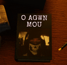 a book titled o agwn mou is sitting on a wooden table