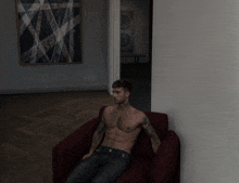 a shirtless man is sitting on a red chair