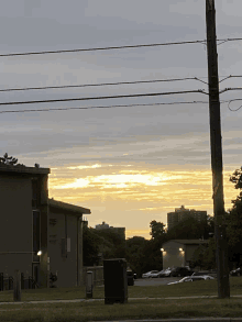 a sunset over a parking lot with a sign that says no parking