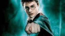 harry potter is pointing his finger at the camera while wearing glasses and a cape .