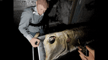 a screenshot of a video game shows a man holding a knife over a dead animal