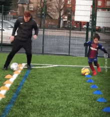 a man and a little girl are playing soccer on a field with a watermark that says ' aratagym '