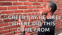 a man standing in front of a brick wall with the words greeb bay be like where did this come from written on it