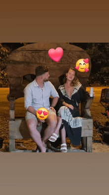 a man and a woman are sitting on a wooden bench in front of a sign that says skellis