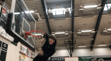 a basketball game is being played in a gym sponsored by grizzly